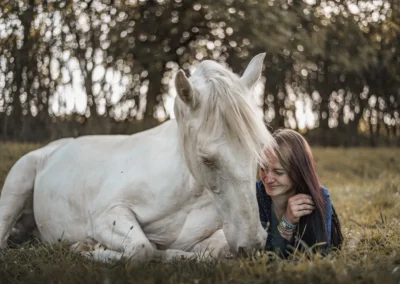 Žena leží v trávě vedle ležícího bílého koně | Jana H Foto